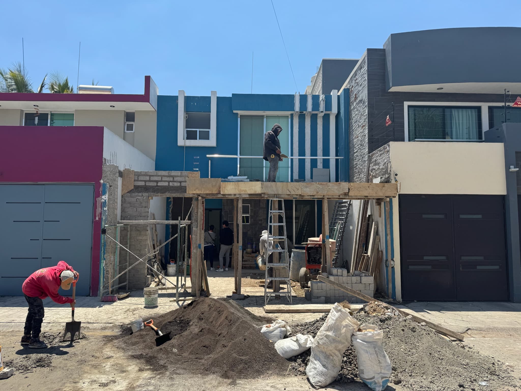 Trabajadores durante la remodelación de una fachada residencial en La Floresta